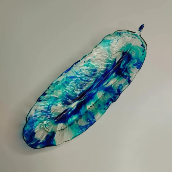 29c8b28f-32f8-4287-aa00-594f083cff02 Vide-poche en forme de feuille avec couleurs turquoise et bleu foncé, parfait pour ranger des petits objets.