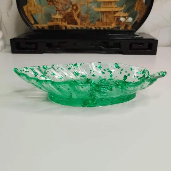 Vide-poche en forme de feuille avec détails sculptés pour les nervures et les bords, pour une touche décorative et naturelle.