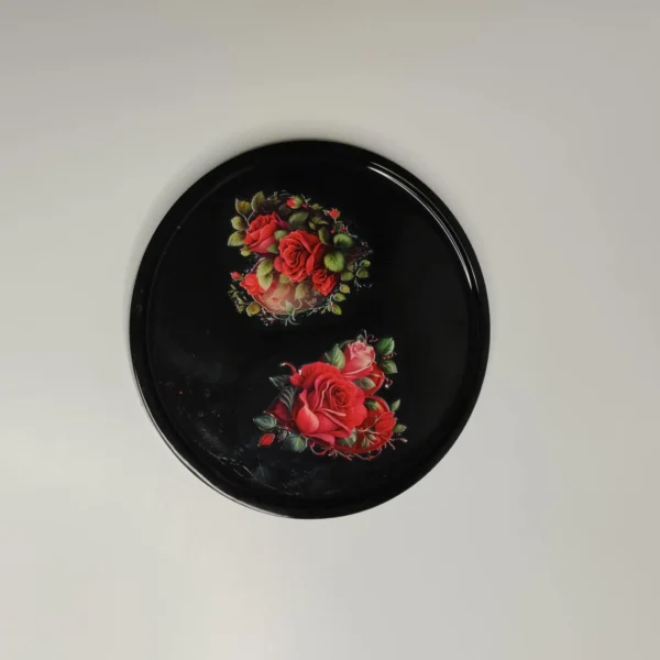 524a2ef0-764b-4259-88ab-e29930f3f94d Plat en résine époxy de forme ronde avec motifs de roses rouges et de feuilles vertes, parfait pour servir des petits objets.