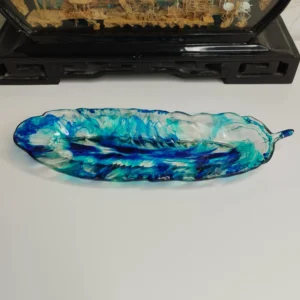 Vide-poche en forme de feuille avec couleurs turquoise et bleu foncé, parfait pour ranger des petits objets.