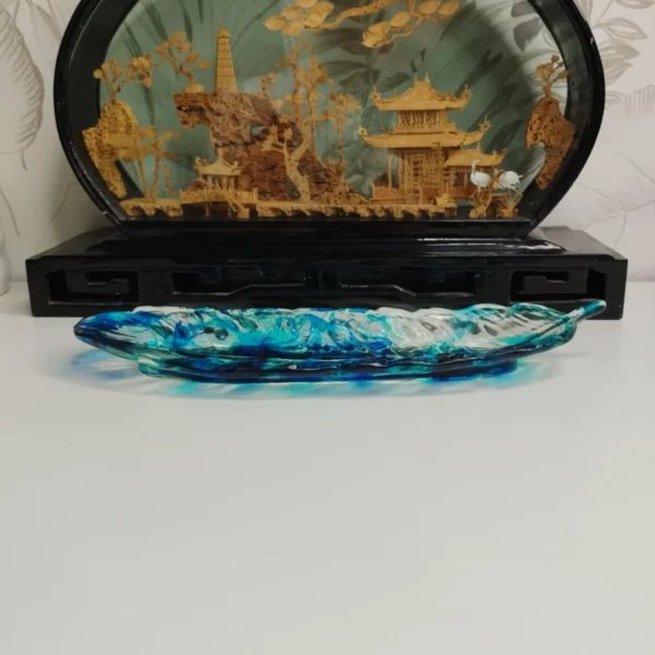 894c2424-5533-48f9-a852-8cfe6fd63538 Vide-poche en forme de feuille avec couleurs turquoise et bleu foncé, parfait pour ranger des petits objets.