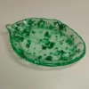 Vue rapprochée sur les nervures finement sculptées de la coupelle en résine époxy, montrant les éclats brillants des paillettes vertes sous la lumière.