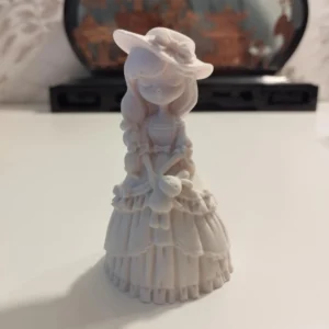 Statuette en jesmonite de 8 cm représentant une jeune fille en robe longue tenant un petit animal, parfaite pour la décoration d'intérieur.