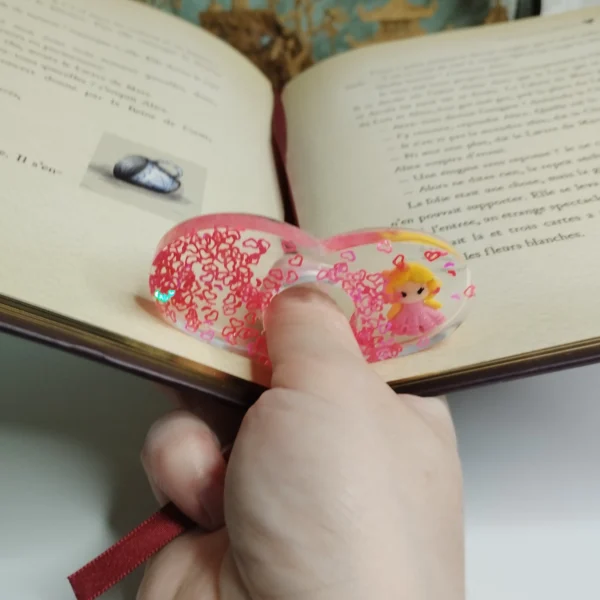 Bague de lecture en résine époxy transparente avec cœurs colorés et figurine de fée.