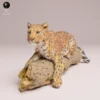 Figurine de léopard de l'Amour à l'échelle 1/24, posée sur un tronc d'arbre texturé.
