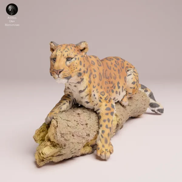 Figurine de léopard de l'Amour à l'échelle 1/24, posée sur un tronc d'arbre texturé.