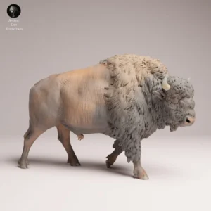 Vue de profil d'une figurine bison en résine non peinte, montrant sa posture de marche dynamique et la musculature détaillée de l'animal, idéale pour les projets de modélisme.