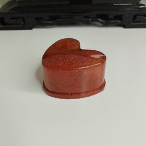Intérieur d'une boîte en résine époxy rouge en forme de cœur avec finition brillante