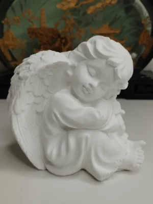 Statuette ange jésmonite blanche – vue d’ensemble Statuette ange en jésmonite blanche 11×11×8 cm, posture recroquevillée et ailes repliées