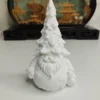 Un petit père Noël en résine blanche avec un sapin posé sur la tête, prêt à être peint avec des couleurs festives.