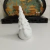 La figurine du père Noël trônant sur une étagère en bois clair, entourée d'une ambiance de décoration de fêtes chaleureuse.