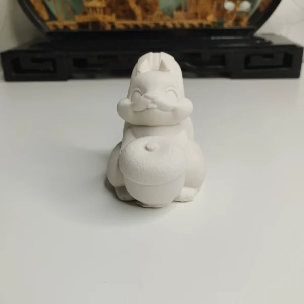 Gros plan sur la texture très douce de ce petit écureuil blanc décoratif, posé sur un bureau en bois.
