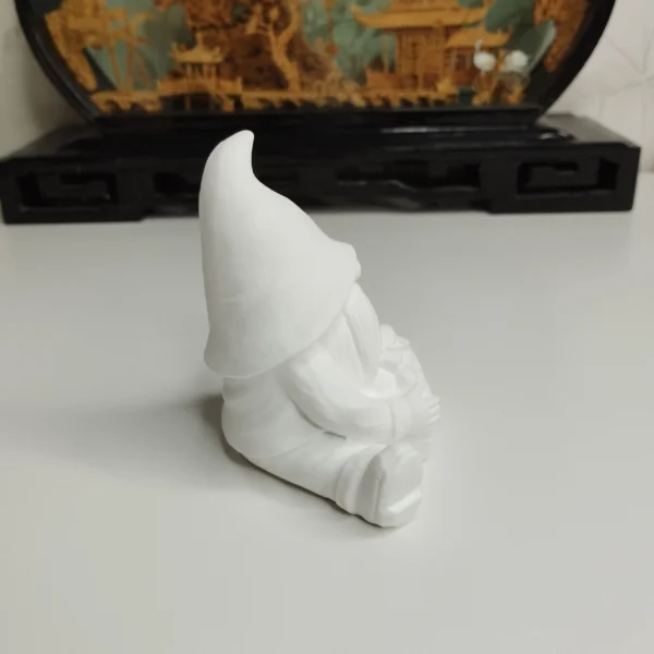 statuette-lutin-panier-pommes-profil Vue de côté du petit lutin rustique, mettant en évidence les jolis plis fluides de son manteau et la belle texture blanc crème de la résine acrylique.