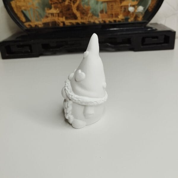 Statuette de gnome en résine acrylique, détail des motifs en relief (cœurs et fleurs).