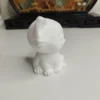 Profil d'une petite figurine chat style chibi montrant sa tête ronde et ses petites pattes repliées, idéale pour une décoration d'étagère.
