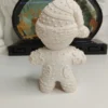 figurine-biscuit-noel-personnalisable-profil Vue de profil d'une décoration de Noël artisanale en résine représentant un biscuit festif. On aperçoit les détails en relief sur ses manches qui imitent un glaçage sucré en zigzag.