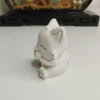 figurine-chat-resine-blanche-profil Vue de profil d'une statuette de chat en résine, montrant sa queue joliment enroulée autour de son corps aux contours d'une grande douceur.