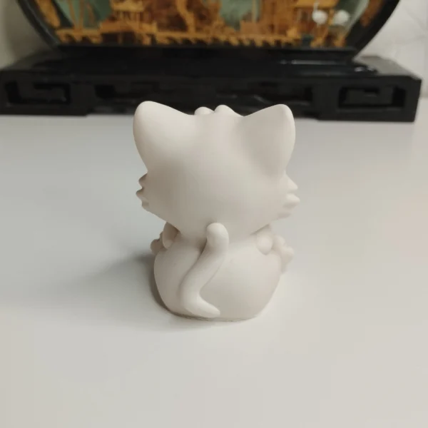 decoration-chat-minimaliste-ambiance Ambiance chaleureuse avec une figurine chat mignon intérieur placée sur une étagère à côté d'une petite plante verte et de quelques livres.