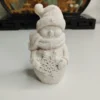 bonhomme-neige-resine-face-relief Figurine souriante de bonhomme de neige avec un bonnet tricoté et une écharpe, dévoilant un beau flocon de neige en relief sur le ventre, prête à être peinte.