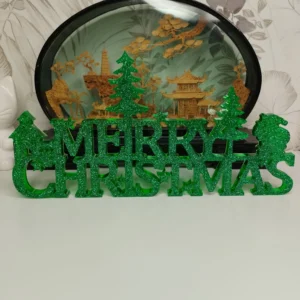 Vue de face d'une décoration de Noël verte en résine, affichant l'inscription Merry Christmas avec des flocons et des sapins scintillants.
