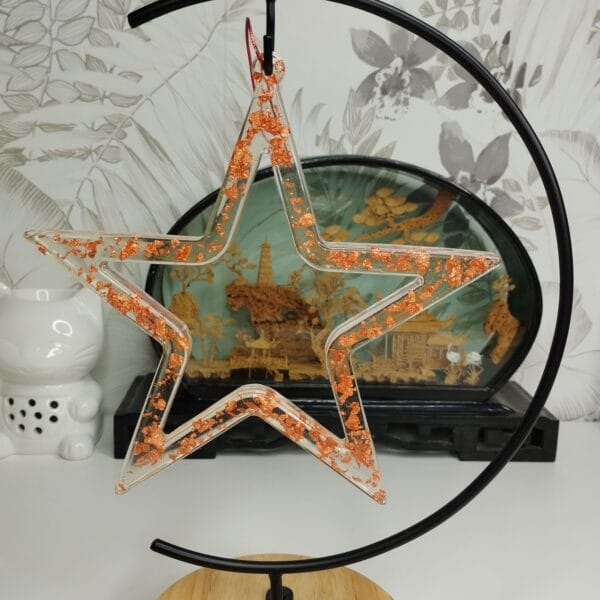 Étoile cuivrée posée sur une table avec des guirlandes lumineuses