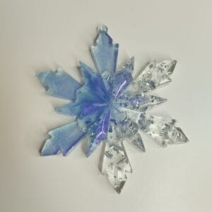 Gros plan sur le dégradé bleu et les paillettes argentées de l'ornement flocon de neige