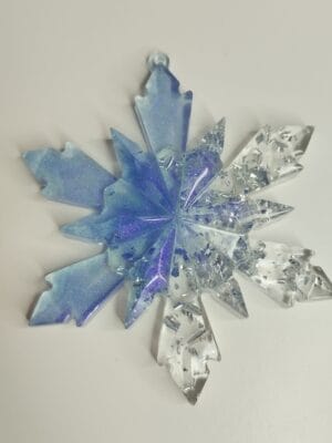 Gros plan sur le dégradé bleu et les paillettes argentées de l'ornement flocon de neige