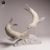 duo-phoques-nage-diorama Deux figurines miniatures de phoques à fourrure du Cap nageant gracieusement autour d'un rocher, fixées sur des supports transparents pour simuler l'eau d'un diorama.
