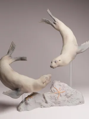 duo-phoques-nage-diorama Deux figurines miniatures de phoques à fourrure du Cap nageant gracieusement autour d'un rocher, fixées sur des supports transparents pour simuler l'eau d'un diorama.