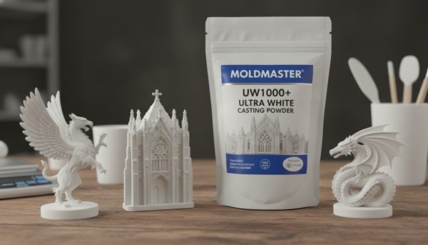 Photo de haute qualité d'un sachet de poudre de moulage MoldMaster UW1000+ ultra blanche posé sur un atelier en bois à côté de sculptures en relief finement détaillées, lumière douce de studio.