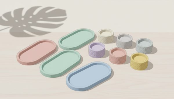 Une collection de moules silicone souples aux formes variées comme des plateaux ovales et des petits pots, disposés de manière esthétique, style minimaliste.