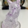 Détail des paillettes violettes en suspension dans la statue loup transparente.