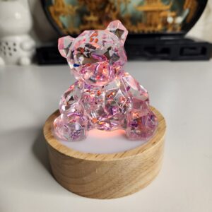 Figurine ourson en résine transparente avec inclusions de feuilles d'or vue de face.