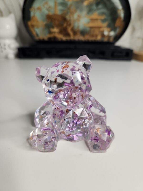 L'ourson transparent feuilles d'or posé sur un bureau moderne près d'une lampe.