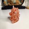 La petite licorne décorative de 8 cm posée harmonieusement sur une table de chevet en bois.