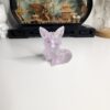 Le petit renard décoratif transparent et violet posé élégamment sur une surface en bois clair.