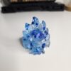 Gros plan sur les lignes texturées des queues et les feuilles métalliques bleues étincelantes à l'intérieur de la résine.