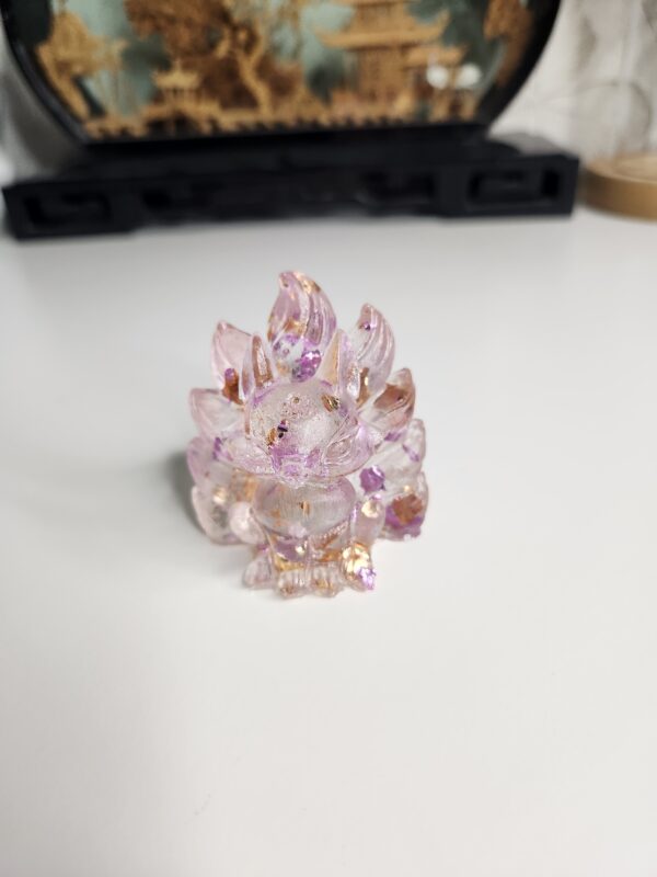 Figurine miniature du renard à neuf queues Kitsune en résine transparente avec feuilles d'or et éclats roses.