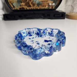 Magnifique vide-poche en forme de cœur en résine transparente avec des éclats métalliques bleu saphir.