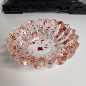 Élégant vide-poche rond au design floral en résine transparente incrusté d'éclats rouge rubis.