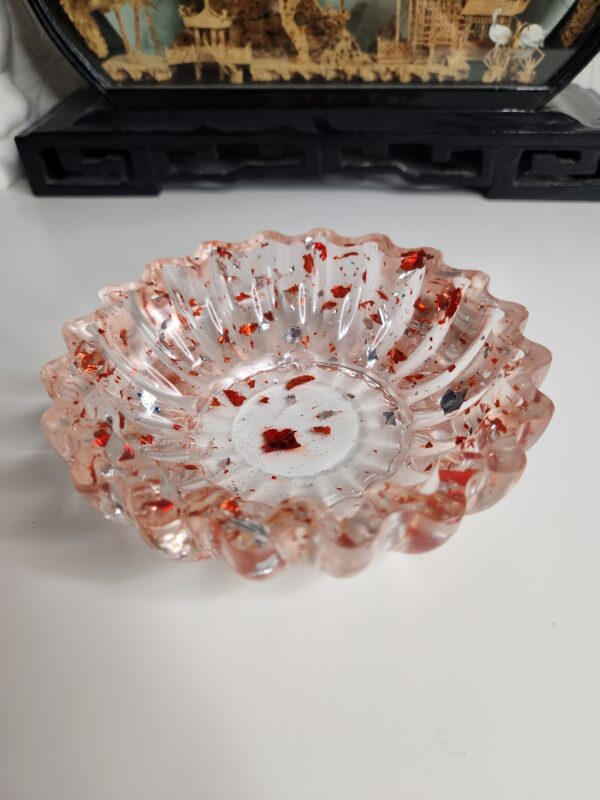 vide-poche-rond-floral-resine-rouge Élégant vide-poche rond au design floral en résine transparente incrusté d'éclats rouge rubis.