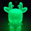 Lueur vert fluo intense émise dans l'obscurité par la veilleuse enfant originale en résine.