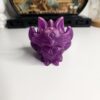 Statuette kitsune violette translucide en résine époxy exposée à la lumière du jour.
