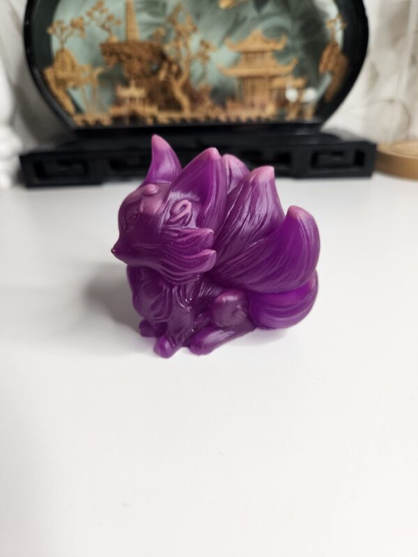 Gros plan sur les détails gravés du pelage et les neuf queues de la figurine folklore asiatique.