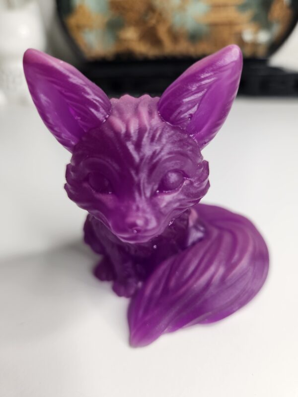 Détails des yeux en amande et de la queue touffue sur le renard décoratif violet.