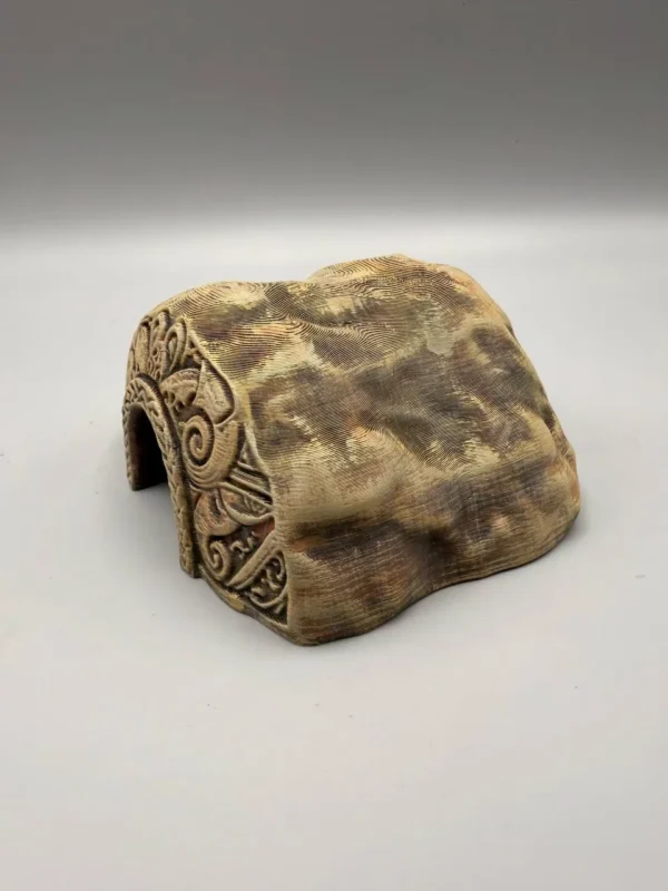 grotte-pour-reptile-demi-dome Détail de la grotte pour reptile demi-dôme montrant les gravures tribales maoris et l'intérieur lisse.
