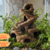 Décor tour rocheuse terrarium à peindre avec grottes, mis en situation dans un aménagement terrarium vertical luxuriant.