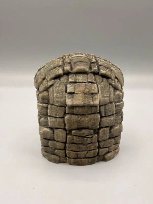 Vue de trois-quarts mettant en valeur les ornements d'oreilles et les fines strates rocheuses de ce décor archéologique pour aquarium et terrarium.