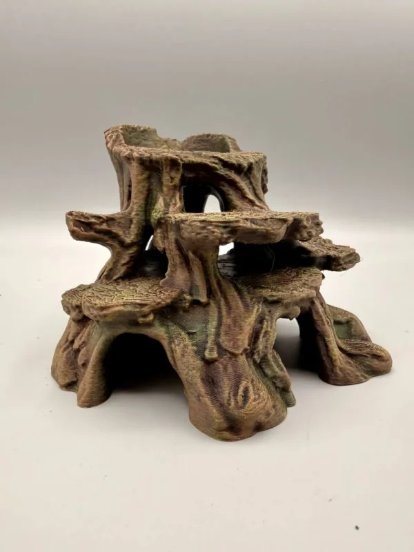 Aménagement de terrarium humide réussi avec la souche d'arbre artificielle installée dans la mousse végétale.