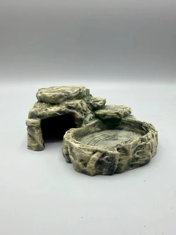 cachette-gamelle-eau-integree-terrarium Vue rapprochée de la texture rocheuse de la cachette gamelle eau intégrée terrarium, montrant les détails de l'impression 3D haute précision.